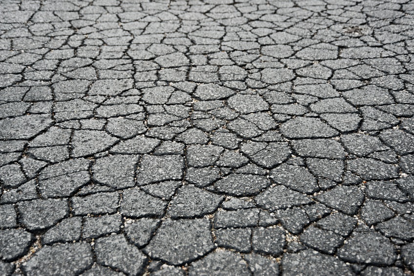 asphalt-repair-stamford-cty-1 Cracked, dry ground surface with irregular patterns, resembling drought or dehydration effects.
